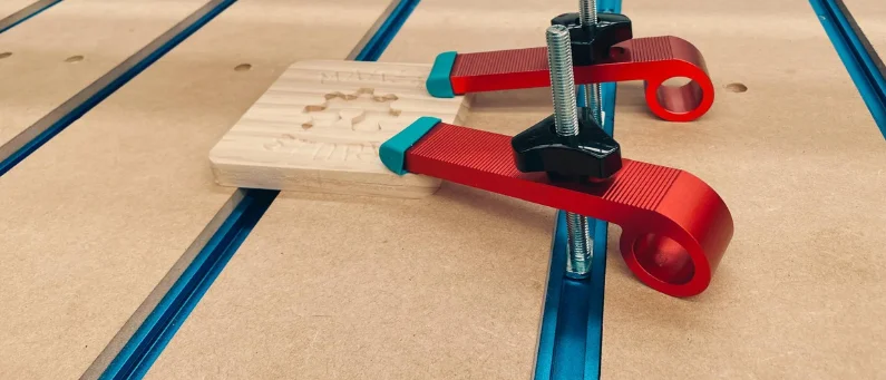 T-Track Based MDF Spoiler Board Displaying two T-Tracks Clamping A Workpiece