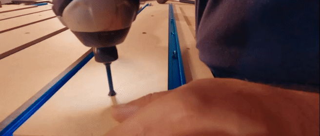 Close up GIF showing screwing down of T-Track onto spoiler board along with screwing down sliced sheets of MDF.